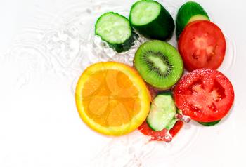 fresh fruits and vegetables in water on a white background