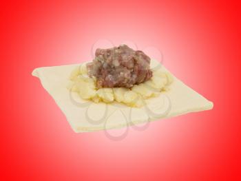 dough with meat on a red background