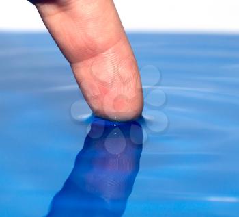 finger in the blue water. macro