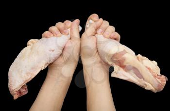 chicken leg in hand on a black background