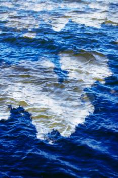 sky with clouds reflected on the water surface with waves