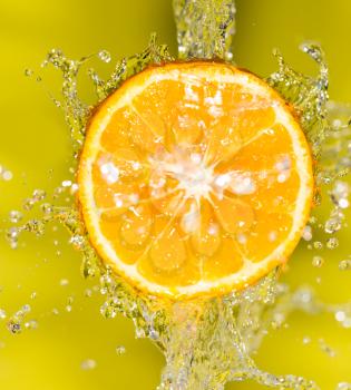 orange in water on a yellow background background