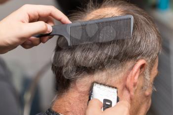 Close up of a male student having a haircut with hair clippers