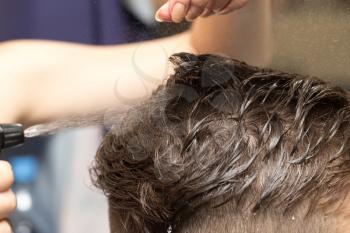 Rear view of man getting a haircut in beauty salon