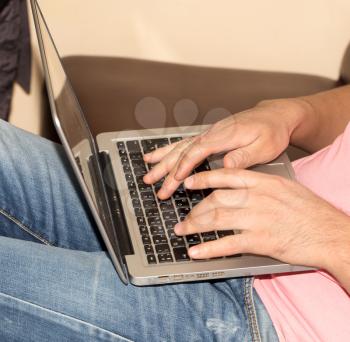 man in jeans with a laptop