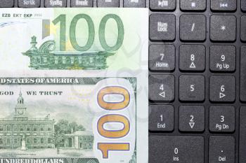 dollars and euros on a laptop keyboard