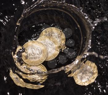 coins in water splashes on a black background