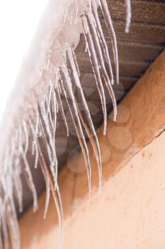 icicles on a roof of a house in winter