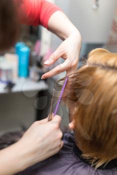 Female hair cutting scissors in beauty salon