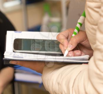 she writes in a notebook with a calculator