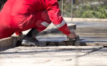 Construction workers leveling concrete pavement.