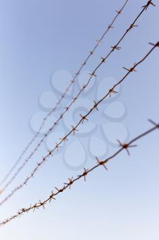 Barbed wire against the blue sky