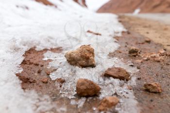 snow on red clay in nature