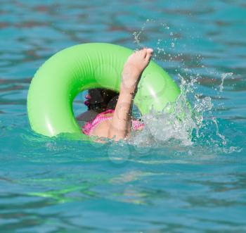 girl with a green balloon in the pool