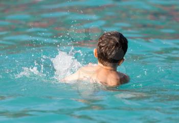 boy swims with a splash in the water park