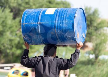 man carries a large barrel