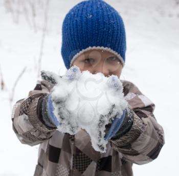 Boy playing with snow in winter