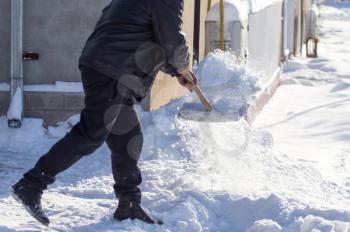 Worker removes snow from the road in nature