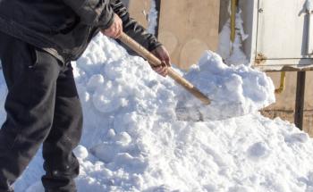 Worker removes snow from the road in nature