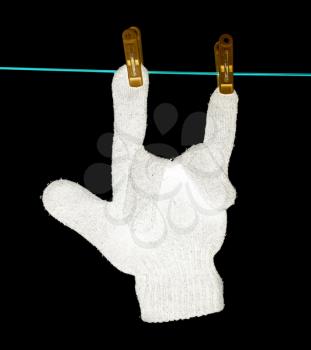 The glove is dried on a rope on a black background .