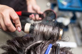 Styling female hair dryer in the beauty salon