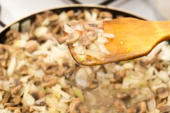 Mushrooms with onions are fried in a frying pan .