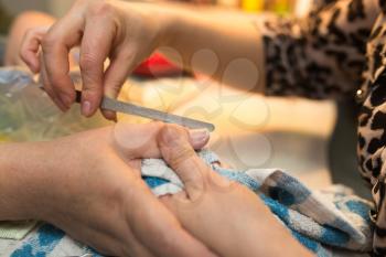 Female manicure on hands in a beauty salon .