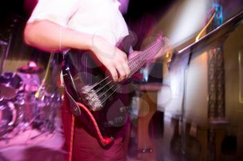 Musician playing guitar in a rock band .