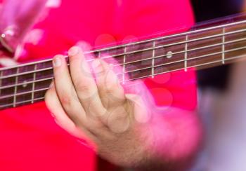 Musician playing guitar in a rock band .