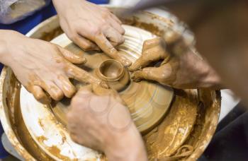 The master makes by hands the product of dishes from clay