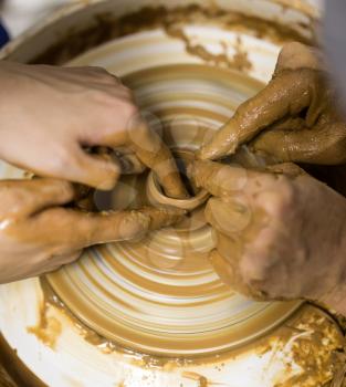 The master makes by hands the product of dishes from clay