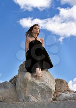 Royalty Free Photo of a Girl Sitting n a Stone