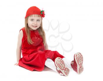 Cute little girl in a red dress sitting on the floor. Isolate on white.