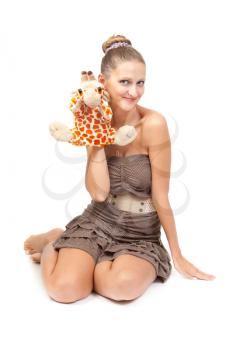 Portrait of beautiful girl sitting on the floor in the studio with plush toy in the shape of a giraffe. isolate on white background.