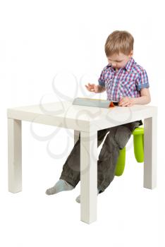 boy with a Tablet PC on the desk in the studio on a white background