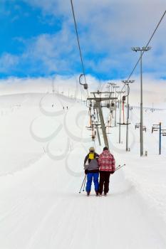 Ski-lift, skiers climb the mountain