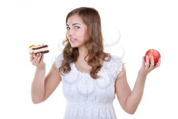 Young beautiful woman choose from sweet cake and red apple