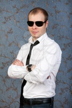 portrait of a young man in sunglasses on the retro background