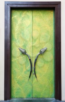 Plush green door with his hands in a brown frame