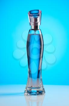 Womens perfume bottle on a blue background with a gradient light spot.