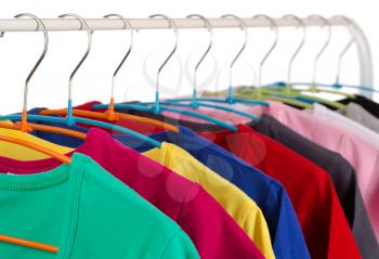 Colorful shirts on hangers, isolate on white.