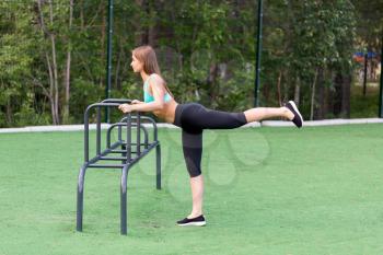 beautiful girl in sportswear on the playground doing fitness.