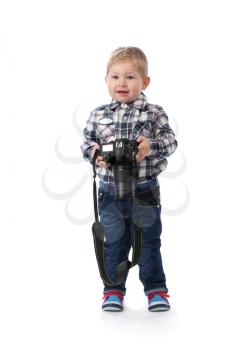 The three-year boy with a camera in hand in the studio. An isolate white.