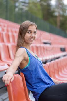 Portrait of a smiling brunette girl at the stadium.