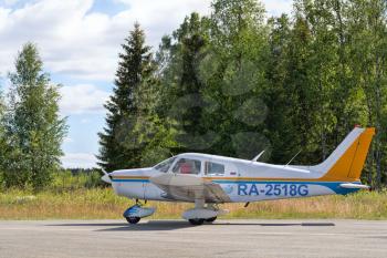 small private plane on the runway in the woods.