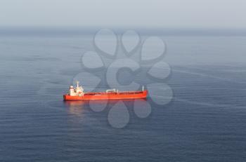 Red tanker ship at sea, the mist on the horizon.