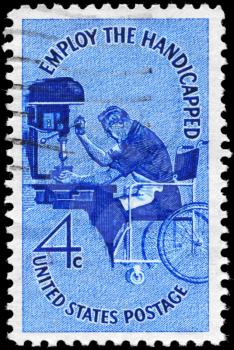 Royalty Free Photo of 1960 US Photo Shows a Man in Wheelchair Operating Drill Press, Employ the Handicapped Issue