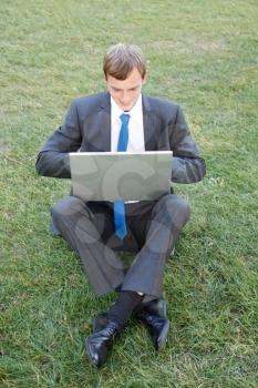 Royalty Free Photo of a Businessman Working on a Laptop Outdoors