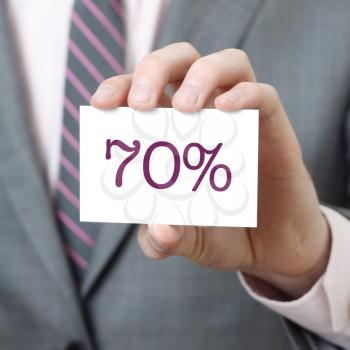 70% written on a card held by a businessman