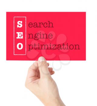 Search Engine Optimization explained on a card held by a hand